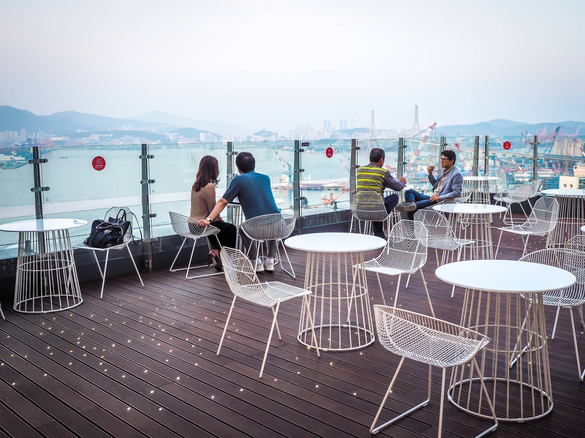 Outdoor patio of Maxim’s de Paris cafe with view of Busan Harbor